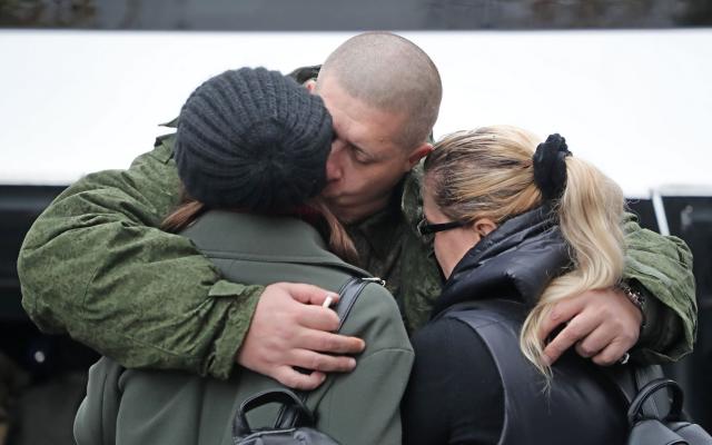 A Russian conscript hugs family members - MAXIM SHIPENKOV/EPA-EFE/Shutterstock
