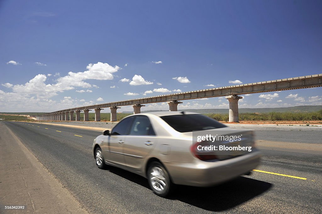 an-automobile-passes-along-a-highway-past-a-section-of-the-new-tsavo-picture-id516342392