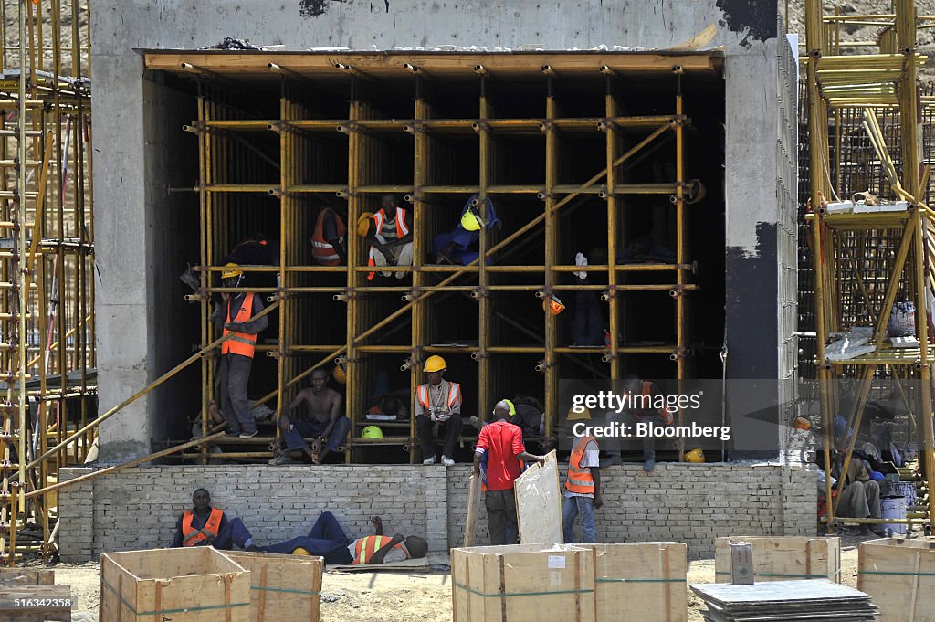 construction-workers-rest-in-the-shade-of-an-unfinished-structure-for-picture-id516342358