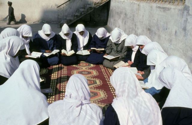 Women kneeling and reading books