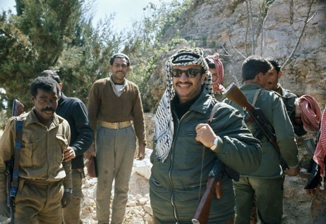 Yasser Arafat standing with armed men