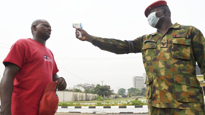 A soldier points a thermometer at a man at the Nigerian Army Reference Hospital in Lagos, Nigeria - Friday 28 February 2020