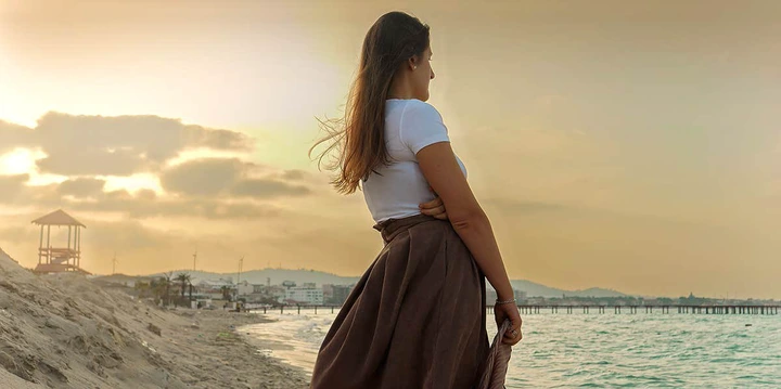 girl standing alone watching ocean