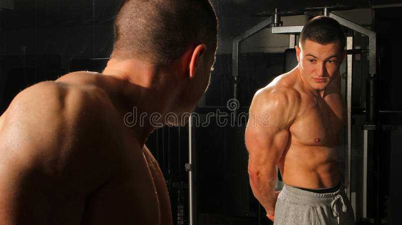 bodybuilder-posing-front-mirror-38125373.jpg