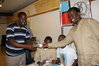 Vua gamba vaa gwanda mwenyekiti akitoa kadi kwa wanachama wapya.JPG