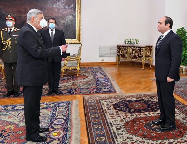 In this photo provided by Egypt's presidency media office, Egyptian President Abdel-Fattah el-Sissi, right, swears in Judge Boulos Fahmy, as the first-ever Coptic Christian to head the country’s highest court, in Cairo, Egypt, Wednesday, Feb. 9, 2022. The 65-year-old is the 19th person to preside over the Supreme Constitutional Court since it was established in 1969. (Egyptian Presidency Media Office via AP)