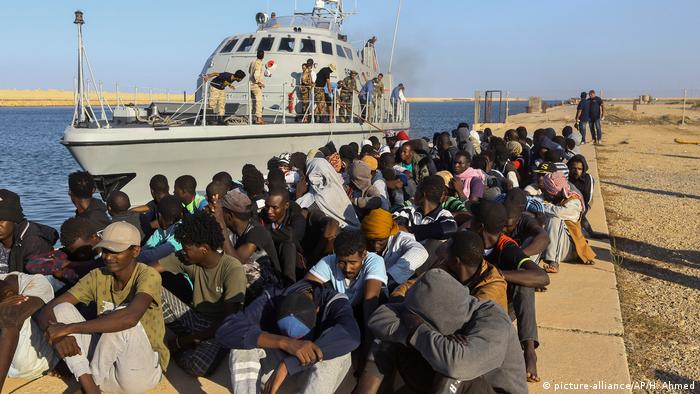 Libyen Khoms Migranten neben Boot der Küstenwache (picture-alliance/AP/H. Ahmed)