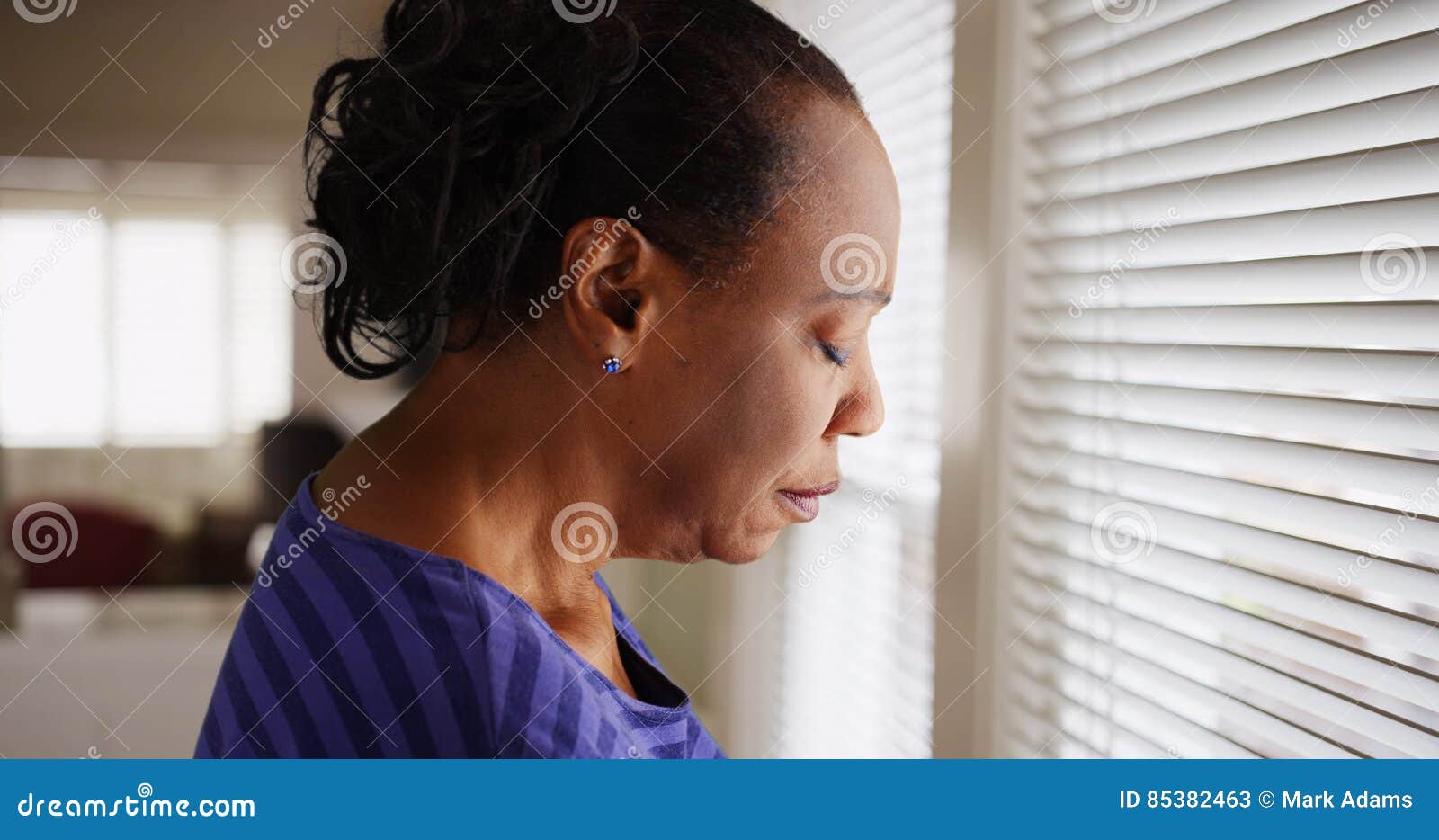 older-black-woman-mournfully-looks-out-her-window-85382463.jpg