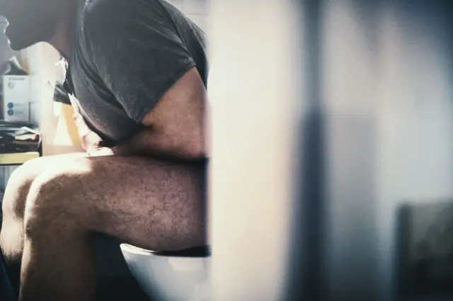 Man sitting at the toilet