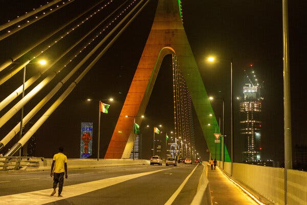 A man walks across a bridge in Abidjan. 