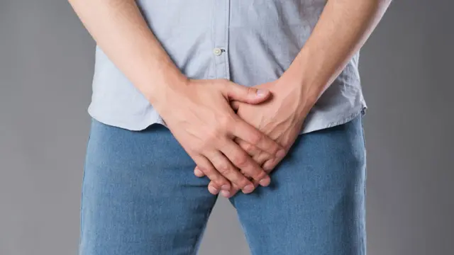 Man blocking his genitals with his hands