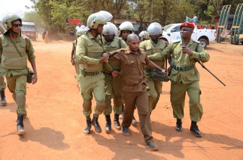 benson-kigaiya-akiwa-chini-ya-ulinzi-wa-polisi-wa-ffu-5-huku-wengine-wakinyatia-kwa-pembeni-akiambulia-makofi-ya-mgongo-na-makalio.jpg