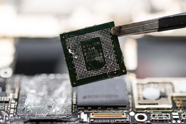 A specialist disassembles a Huawei Technologies Co. Mate 60 Pro smartphone and removes the Kirin 9000s chip. 
