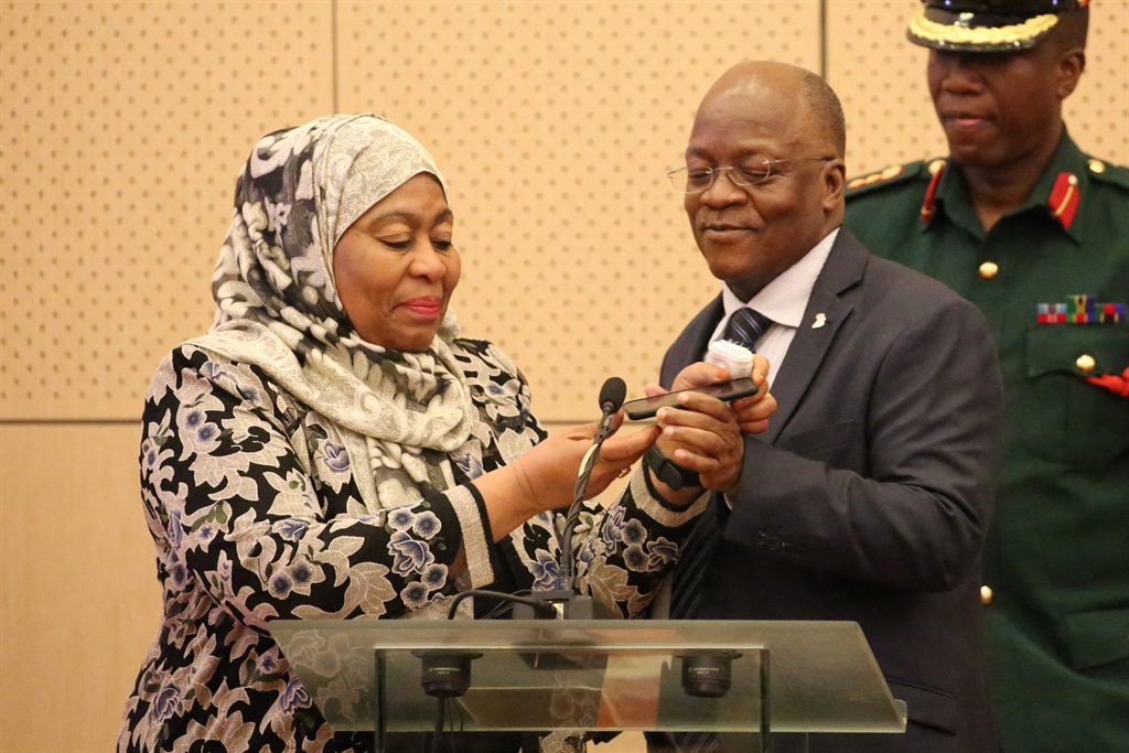 Tanzania's new president Samia Hassan Suluhu (L) and the late former president of Tanzania John Magufuli (C) speaking with Kenya's President Uhuru Kenyatta on the phone at the State House in Dar es Salaam, Tanzania, on July 24, 2019.