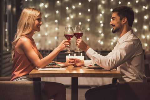 couple staring into each others eyes while drinking wine