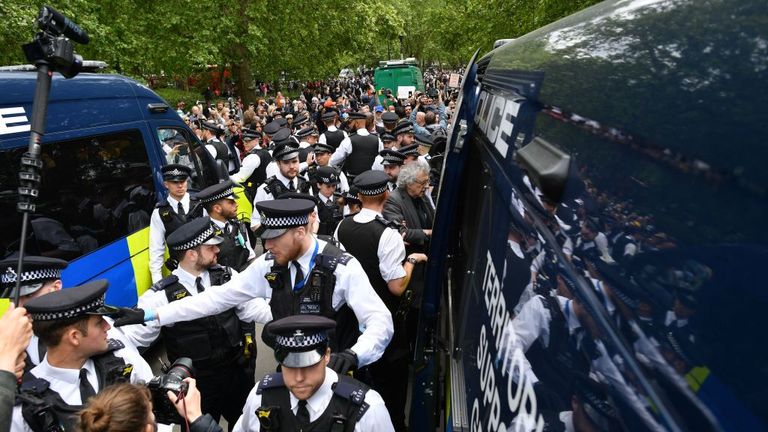Piers Corbyn (C - grey top), brother of former Labour Party leader Jeremy Corbyn, is led away by police officers into a police van at an anti-coronavirus lockdown demonstration in Hyde Park in London on May 16, 2020, following an easing of lockdown rules in England during the novel coronavirus COVID-19 pandemic. - Fliers advertising 'mass gatherings' organised by the UK Freedom Movement to oppose the government lockdown measures and guidelines put in place to halt the spread of coronavirus in pa'mass gatherings' organised by the UK Freedom Movement to oppose the government lockdown measures and guidelines put in place to halt the spread of coronavirus in pa