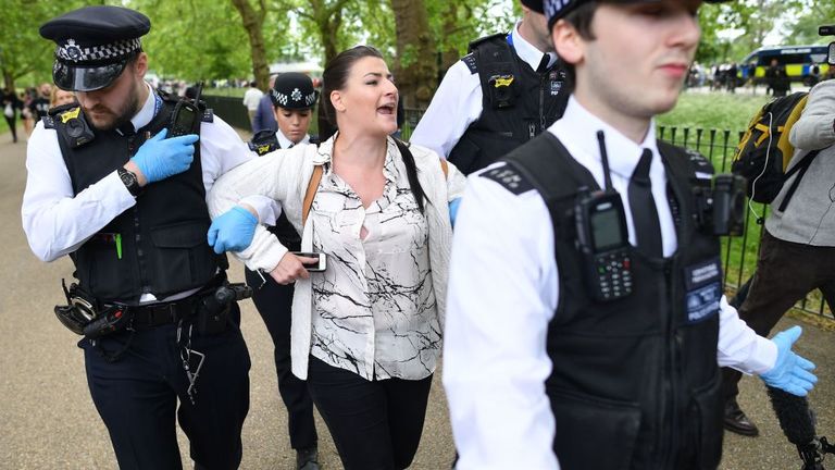 A woman is arrested by police officers at an anti-coronavirus lockdown demonstration in Hyde Park in London on May 16, 2020, following an easing of lockdown rules in England during the novel coronavirus COVID-19 pandemic. - Fliers advertising 'mass gatherings' organised by the UK Freedom Movement to oppose the government lockdown measures and guidelines put in place to halt the spread of coronavirus in parks around the UK calling for attendees to bring a picnic and music have been circulating on