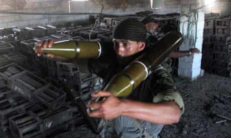 Libyan fighters carrying ammunition from