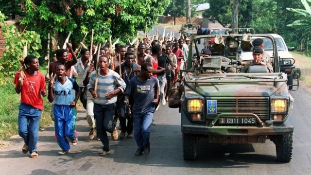 Juni 1994: Wanajeshi w Ufaransa wakiwa katika doria wakipita kwenye umati wa wanamgambo wa Kihutu nchini Rwanda. Wanamgambo hao walitumika katika utekelezaji wa mauaji ya kimbari