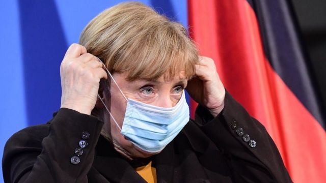 German Chancellor Angela Merkel puts on a face mask after a press conference at the chancellery in Berlin, Germany, 30 March 2021.