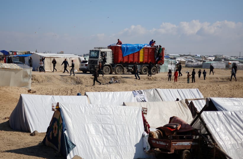 A truck carrying aid arrives at a tent camp, as Displaced Palestinians who fled their houses due to Israeli strikes, take shelter there amid the ongoing conflict between Israel and Hamas, near the border with Egypt in Rafah in the southern Gaza Strip, February 6, 2024. (photo credit: REUTERS/MOHAMMED SALEM)