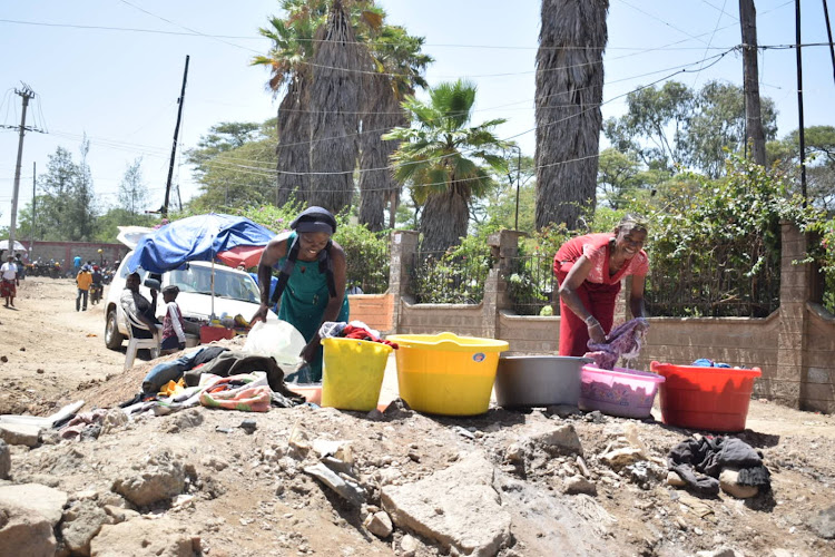 Women wash clothes right across debris of the demolished road sections at Mukuru Kayaba in an effort to make ends meet amidst tough economic times the area faces. January 27, 2022