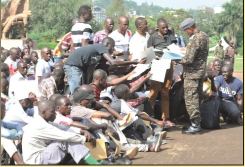 A soldier checking the documents of people who want to join the army recently. The UPDF also considers academic qualiﬁ cation and profession while recruiting