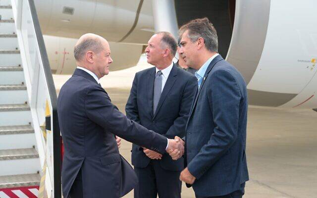 German Chancellor Olaf Scholz (left) arrives in Israel on October 17, 2023, and is greeted by Foreign Minister Eli Cohen (right). (Shlomi Amsallem/Foreign Ministry)