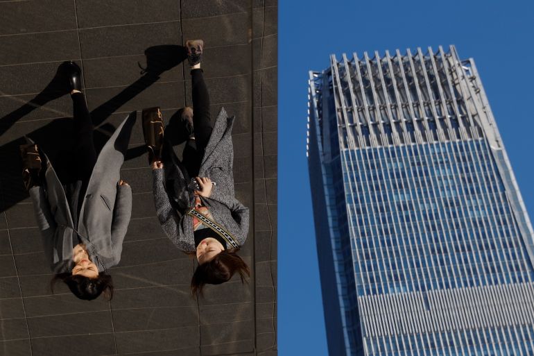 In this March 6, 2019, photo, women are reflected on silver panels of the French luxury brand Louis Vuitton flagship store at the Central Business District in Beijing. China will bar government authorities from demanding overseas companies hand over technology secrets in exchange for market share, a top economic official said Wednesday, addressing a key complaint at the heart of the current China-U.S. trade dispute. (AP Photo/Andy Wong, File)