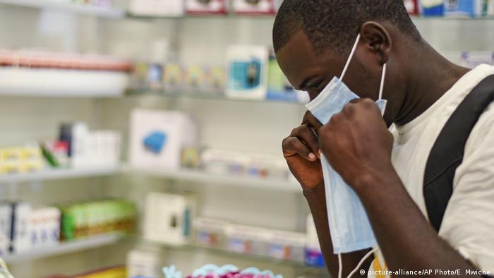 A man tries on a face mask in a pharmacy