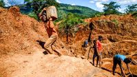 A miner carries ore at Manzou Farm
